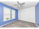 Bright bedroom with blue accent wall, neutral carpet, a modern ceiling fan, and natural light from two windows at 836 Grassy Branch Dr, Indianapolis, IN 46239