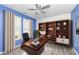 Stylish home office featuring built-in shelving, a modern desk, and two bright windows with elegant curtains at 836 Grassy Branch Dr, Indianapolis, IN 46239