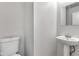 Bathroom showcasing white toilet, pedestal sink and mirror at 8808 Hosta Way, Indianapolis, IN 46113