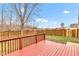 Red wooden backyard deck framed by a wood fence and bare trees at 8808 Hosta Way, Indianapolis, IN 46113