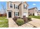 Close-up of a home with a black front door, neat landscaping, and an attached one-car garage at 8808 Hosta Way, Indianapolis, IN 46113