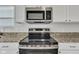Stainless steel microwave and range above the flat cooktop in the kitchen at 8808 Hosta Way, Indianapolis, IN 46113