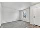 Neutral living room with gray carpet, white walls, one window, and a white door at 8808 Hosta Way, Indianapolis, IN 46113