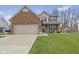 Inviting two-story home with a brick and siding exterior, attached garage, and well-kept lawn at 894 Woodgate Ln, Greenwood, IN 46143