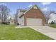 Side view of the home with a two-car attached garage and well-maintained yard with an outbuilding at 894 Woodgate Ln, Greenwood, IN 46143