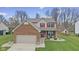 Charming two-story home featuring a brick facade, red shutters, manicured lawn, and attached two-car garage at 894 Woodgate Ln, Greenwood, IN 46143