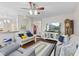 Cozy living room showcasing hardwood floors, neutral sofas, and a large television at 894 Woodgate Ln, Greenwood, IN 46143