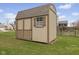 Backyard shed featuring painted horizontal siding with a dark brown trim, gable roof and a window at 894 Woodgate Ln, Greenwood, IN 46143