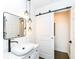 Elegant bathroom boasts a modern vanity with decorative lighting, sleek black fixtures, and barn door access to closet at 902 N Anderson St, Elwood, IN 46036
