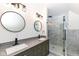 Modern bathroom with double vanity, framed mirrors, and glass enclosed shower with gray tiling at 902 N Anderson St, Elwood, IN 46036
