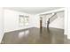 Bright living room features hardwood floors, modern staircase, and a large window providing plenty of natural light at 902 N Anderson St, Elwood, IN 46036