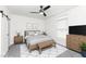Bright, virtually staged main bedroom features natural light, an area rug, and a ceiling fan at 902 N Anderson St, Elwood, IN 46036