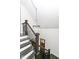 Elegant staircase with dark wood railings and a stylish chandelier, adding a touch of sophistication to the home at 902 N Anderson St, Elwood, IN 46036