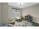Well-lit bedroom with a large window, play-themed area rug, and space for toys and play at 9539 Rocky Shore Dr, McCordsville, IN 46055