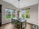 Bright dining room with large windows, modern light fixture and hardwood floors at 9539 Rocky Shore Dr, McCordsville, IN 46055