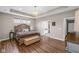 A well-lit main bedroom featuring a tray ceiling, chandelier, and a view into the bathroom through a doorway at 9539 Rocky Shore Dr, McCordsville, IN 46055