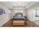 Main bedroom with a tray ceiling, chandelier, and a large bed frame with an upholstered bench in front of it at 9539 Rocky Shore Dr, McCordsville, IN 46055