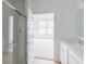 The bathroom boasts a glass shower and white vanity, complemented by natural light from the adjacent bedroom windows at 1023 Grassy Br Dr, Indianapolis, IN 46239