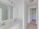 Bright bathroom featuring double sink vanity, large mirror, and shower-tub combo with white finishes throughout at 1023 Grassy Br Dr, Indianapolis, IN 46239