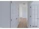 Bright hallway with white doors and light wood-look floors leading into an open area at 1023 Grassy Br Dr, Indianapolis, IN 46239