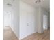 Hallway with white doors, trim, and light wood-look floors in a bright space at 1023 Grassy Br Dr, Indianapolis, IN 46239
