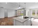 Open concept kitchen with an island, granite countertops, stainless steel appliances, and luxury vinyl plank floors at 1023 Grassy Br Dr, Indianapolis, IN 46239