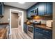 Beautiful kitchen with stainless steel appliances, dark blue cabinets, hardwood countertops, and hardwood floors at 108 Knoll Ct # A, Noblesville, IN 46062
