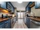 Modern kitchen with stainless steel appliances, dark blue cabinets, hardwood countertops, and hardwood floors at 108 Knoll Ct # A, Noblesville, IN 46062