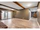 Spacious living room with wood beams, sliding glass doors, hardwood floors, and a red brick fireplace at 108 Knoll Ct # A, Noblesville, IN 46062