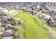 Aerial neighborhood view featuring a golf course, pond, and many homes, capturing the community's landscape at 10844 Fairwoods Dr, Fishers, IN 46037