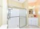 White bathroom features a glass-enclosed shower, single vanity, and tiled floors, offering a clean, minimalist design at 10844 Fairwoods Dr, Fishers, IN 46037