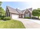 Charming brick home with a well-manicured lawn and a curved driveway leading to an attached two-car garage at 10844 Fairwoods Dr, Fishers, IN 46037
