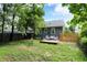 Private backyard oasis featuring a wooden deck, mature trees, and plenty of space for recreation at 112 S Spencer Ave, Indianapolis, IN 46219