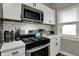 Bright kitchen featuring white cabinetry, subway tile backsplash, and stainless steel appliances at 112 S Spencer Ave, Indianapolis, IN 46219