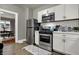 Modern kitchen featuring stainless steel appliances, white cabinets, and stylish subway tile backsplash at 112 S Spencer Ave, Indianapolis, IN 46219