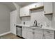 Bright and modern kitchen featuring white cabinets, stainless steel appliances, and sleek countertops at 112 S Spencer Ave, Indianapolis, IN 46219
