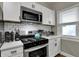 Kitchen featuring stainless steel appliances, white cabinets, and a subway tile backsplash at 112 S Spencer Ave, Indianapolis, IN 46219