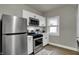 Well-equipped kitchen with stainless steel appliances, white cabinetry and a bright, airy feel at 112 S Spencer Ave, Indianapolis, IN 46219