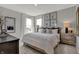 A neutral bedroom features light grey walls, with a well-dressed bed, with decorative wall art at 11599 Aubrey Ln, Fishers, IN 46040