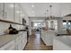 Well-lit kitchen with white cabinetry, island seating, and views to the living area at 11599 Aubrey Ln, Fishers, IN 46040
