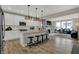 Open kitchen with island, pendant lights, and stainless appliances, flowing into a cozy living area at 11599 Aubrey Ln, Fishers, IN 46040