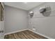 Clean laundry room with wood-look flooring, wire shelving, and modern gray walls for efficient chore management at 11599 Aubrey Ln, Fishers, IN 46040