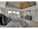 Bright main bedroom showcases a statement wood ceiling, plush carpet, and a large window at 11599 Aubrey Ln, Fishers, IN 46040