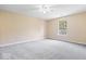 Neutral bedroom features plush carpet, fresh paint, and a window overlooking the front yard at 12741 Glengary Dr, Fishers, IN 46038