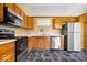 Functional kitchen featuring wooden cabinets, stainless steel appliances, and durable vinyl flooring at 12741 Glengary Dr, Fishers, IN 46038