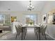 Open dining area with modern table, chandelier, and sliding door to backyard, adjacent to the living room at 12949 Shandon Ln, Fishers, IN 46038