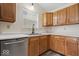 Kitchen featuring a stainless steel dishwasher, undermount sink, and wood cabinets at 12949 Shandon Ln, Fishers, IN 46038