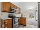 Well-lit kitchen with stainless steel appliances and wood cabinets overlooking the dining area at 12949 Shandon Ln, Fishers, IN 46038
