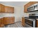 Bright kitchen with stainless steel oven, microwave, wood cabinets, and vinyl flooring at 12949 Shandon Ln, Fishers, IN 46038