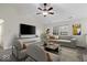 Bright living room featuring modern furniture, a ceiling fan, and natural light from the large window at 12949 Shandon Ln, Fishers, IN 46038